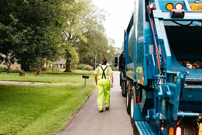 Sanitation worker next to garbage truck