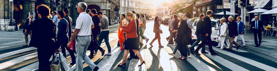 People walking across a crosswalk in a city