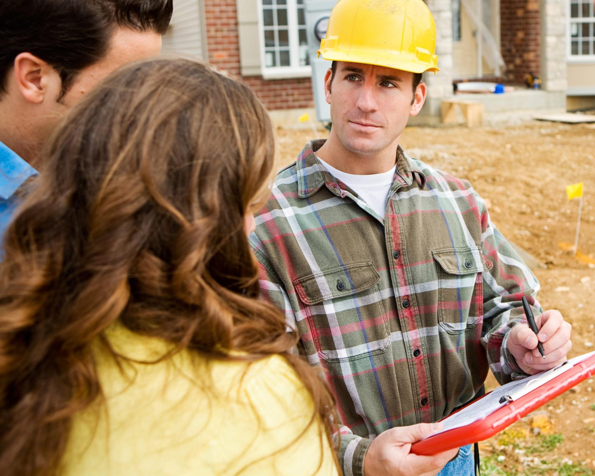 Worker in hardhat meeting with a couple